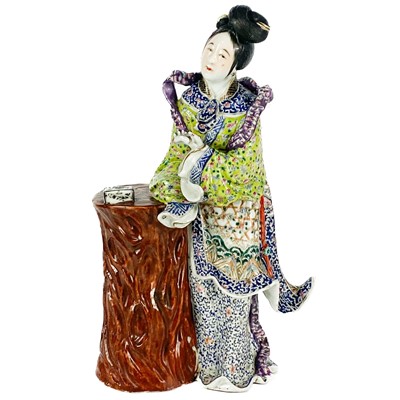 Lot 435 - A Chinese porcelain figure of a lady leaning on a tree stump.