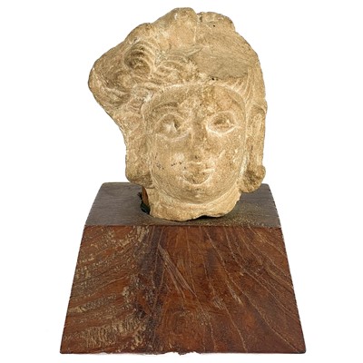 Lot 59 - An Indian stone sculpture head of a deity, probably 12/14th century.