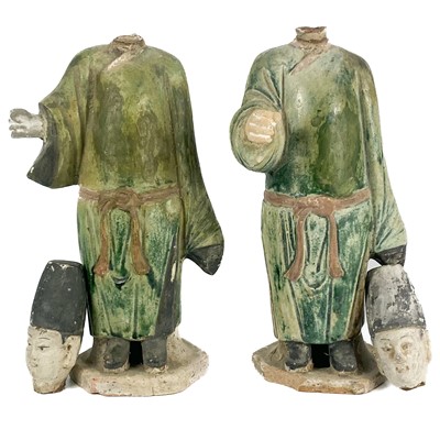 Lot 545 - A pair of Chinese sancai pottery figures of attendants, late Ming Dynasty.