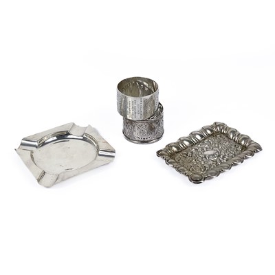 Lot 253 - An Edwardian silver embossed pin tray, an ashtray and two napkin rings.