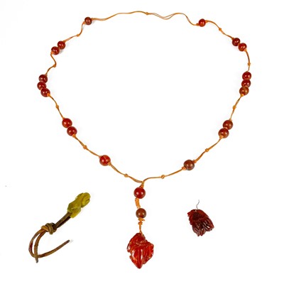 Lot 469 - A Chinese amber bead necklace with two carved pendants.