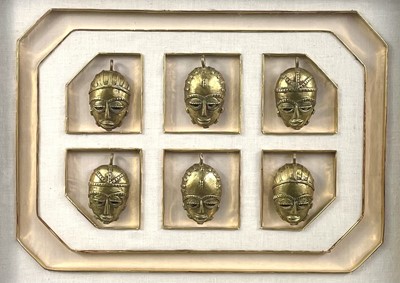 Lot 222 - A collection of six Benin bronze masks in a single frame.