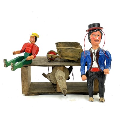 Lot 23 - An amusing painted wood automata of a gentleman on a hay bale.