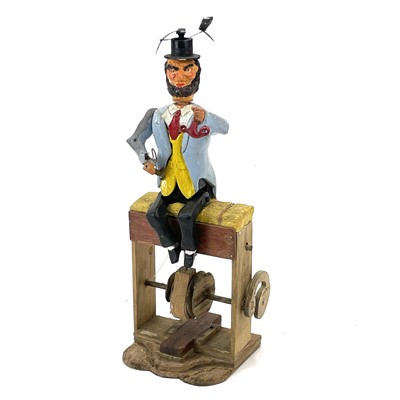 Lot 23 - An amusing painted wood automata of a gentleman on a hay bale.