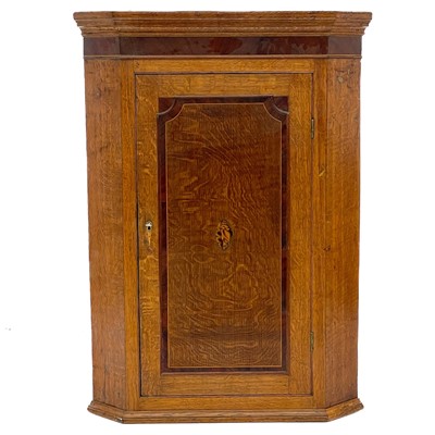 Lot 1874 - A George III oak, mahogany banded and shell inlaid corner cupboard.