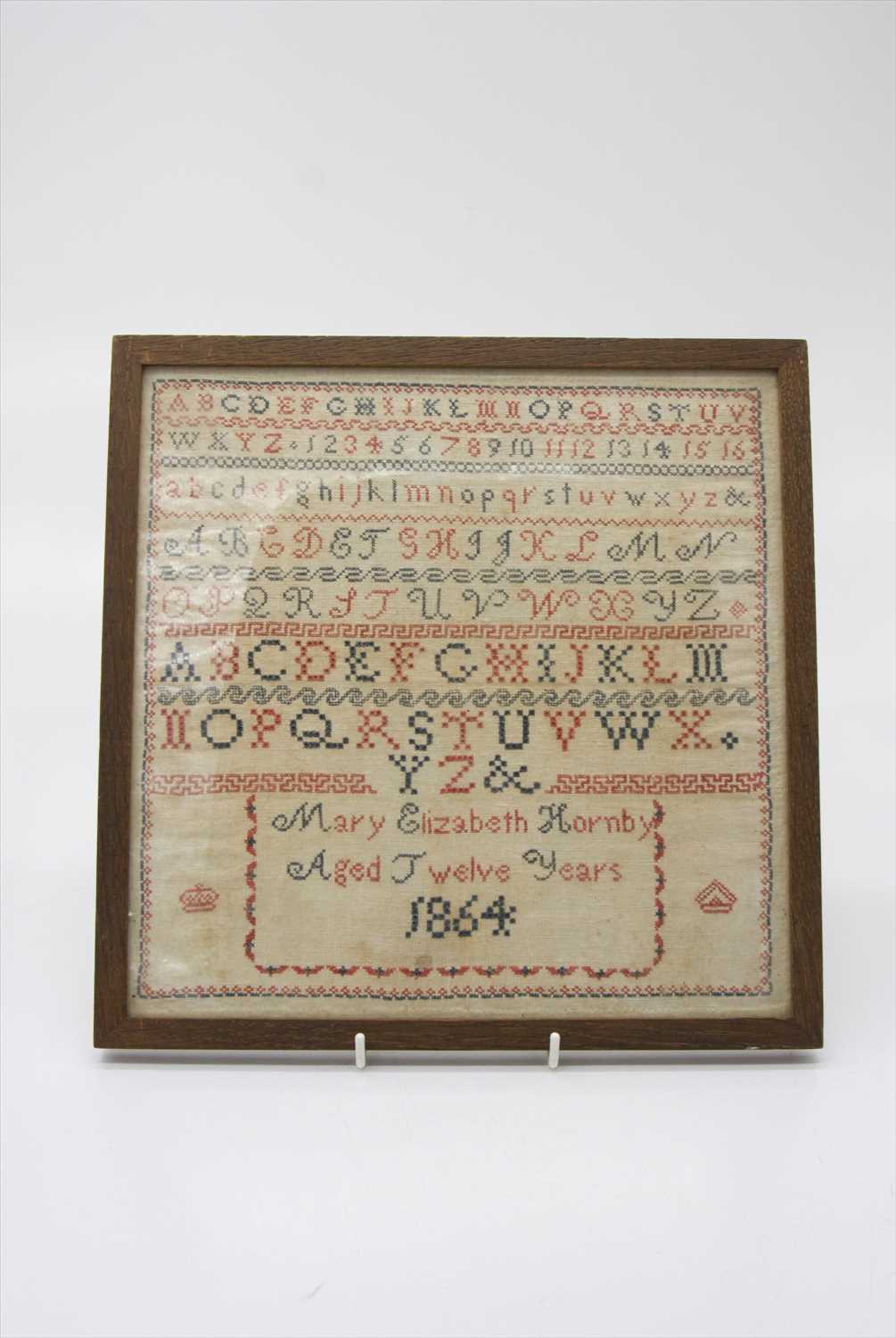 Lot 3108 - A 19th century needlework alphabet sampler,...