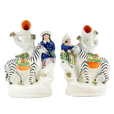 Lot 165 - A pair of Victorian Staffordshire spill vases of zebras.