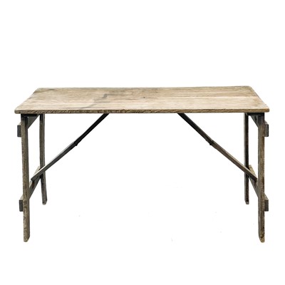 Lot 29 - An oak folding trestle table.