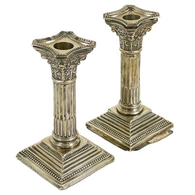 Lot 309 - A pair of Edwardian silver Corinthian column weighted candlesticks.