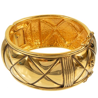 Lot 133 - A Chanel 1980's gold-tone quilted design hinged bangle.