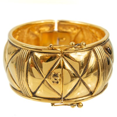 Lot 559 - A Chanel 1980's gold-tone quilted design hinged bangle.