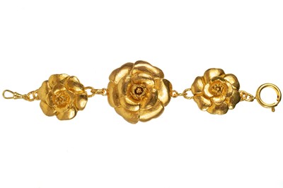 Lot 144 - A Chanel 1980's gold tone triple flower head bracelet.