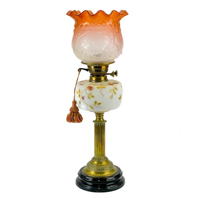 Lot 183 - A Victorian brass oil lamp with opaque glass reservoir decorated with enamels.