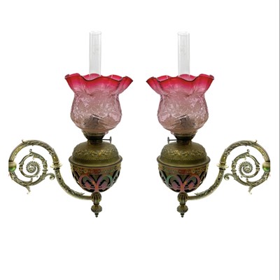 Lot 185 - A pair of Victorian wall bracket brass oil lamps with cranberry glass shades.