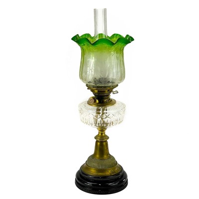 Lot 192 - A Victorian brass oil lamp with glass reservoir and green glass shade.