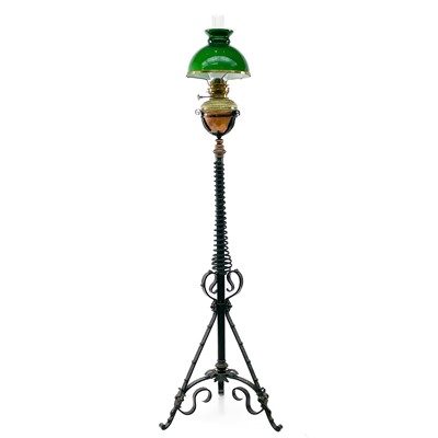 Lot 195 - A Victorian brass oil lamp with green glass shade on a wrought iron base.