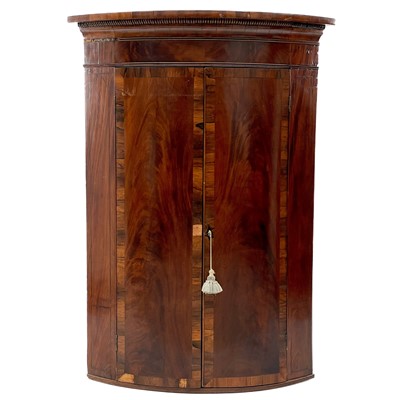 Lot 1911 - A George III mahogany bow front hanging corner cupboard.